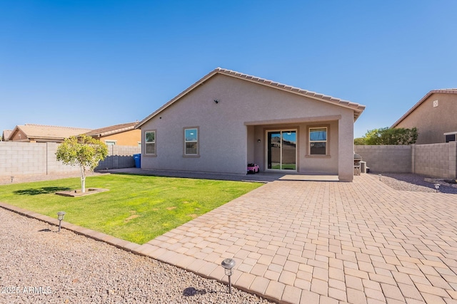 back of house with a yard, a fenced backyard, a patio, and stucco siding