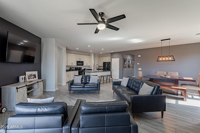 living area featuring ceiling fan, recessed lighting, light wood-type flooring, and baseboards