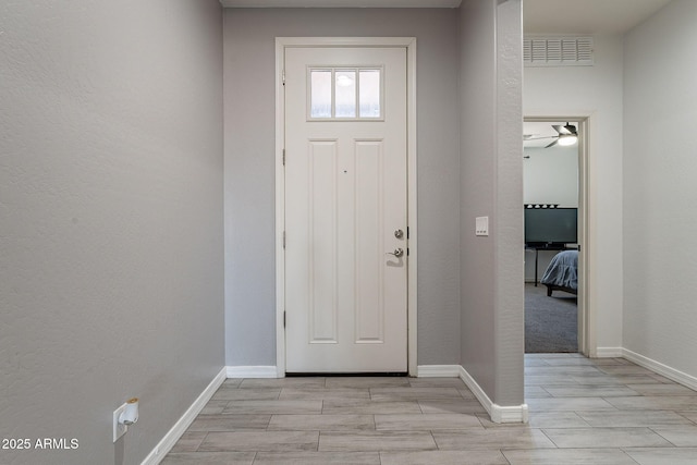 entrance foyer with wood finish floors, visible vents, and baseboards