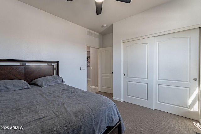 carpeted bedroom with ceiling fan, a closet, visible vents, and baseboards