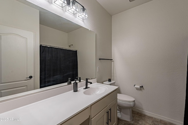 bathroom with a textured wall, toilet, vanity, baseboards, and a shower with curtain