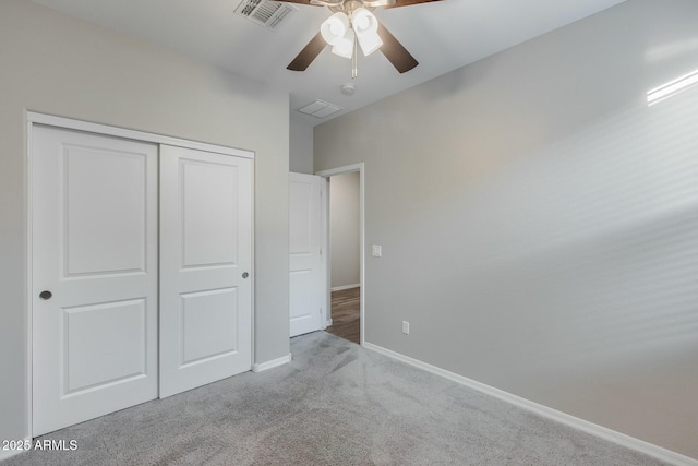 unfurnished bedroom with light colored carpet, a closet, and ceiling fan