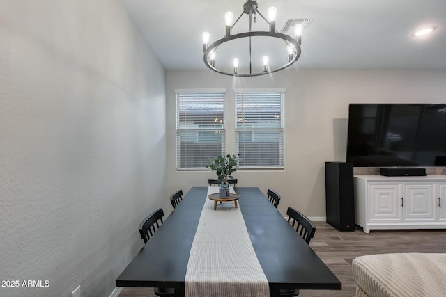 dining room with hardwood / wood-style flooring and a notable chandelier