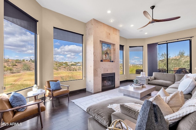 living room featuring recessed lighting, plenty of natural light, wood finished floors, and a tiled fireplace