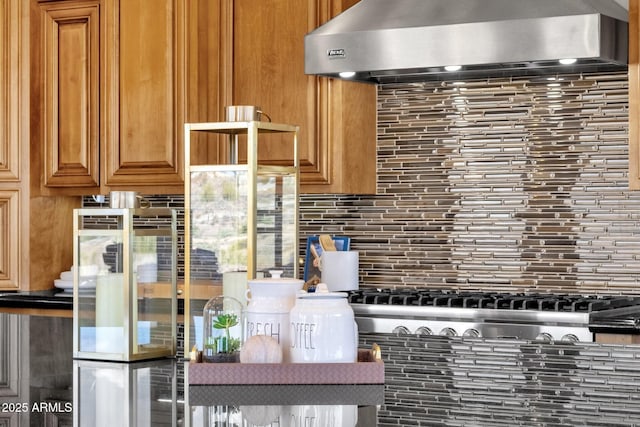 kitchen with wall chimney range hood and backsplash