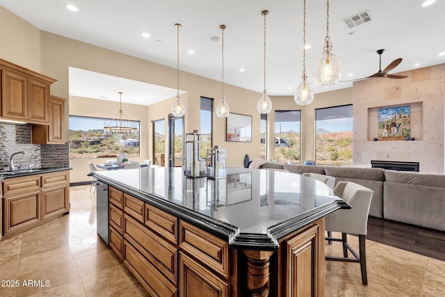 kitchen with a wealth of natural light, visible vents, a large fireplace, and backsplash