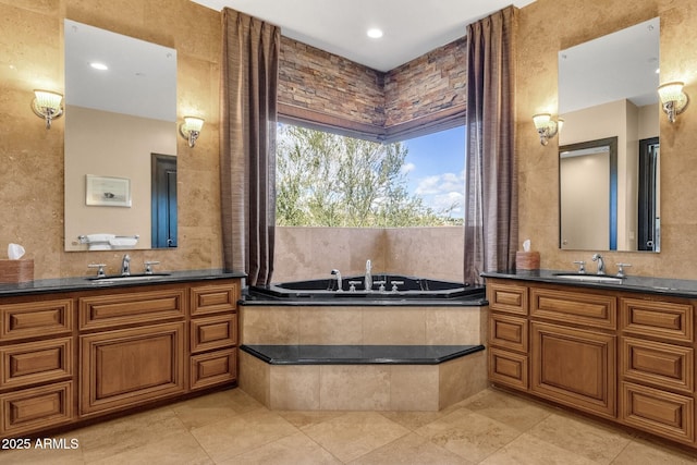 full bathroom featuring a sink, two vanities, and a bath