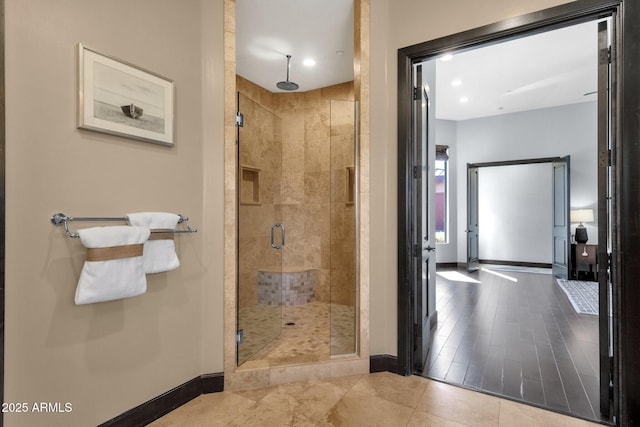 full bathroom featuring baseboards and a shower stall