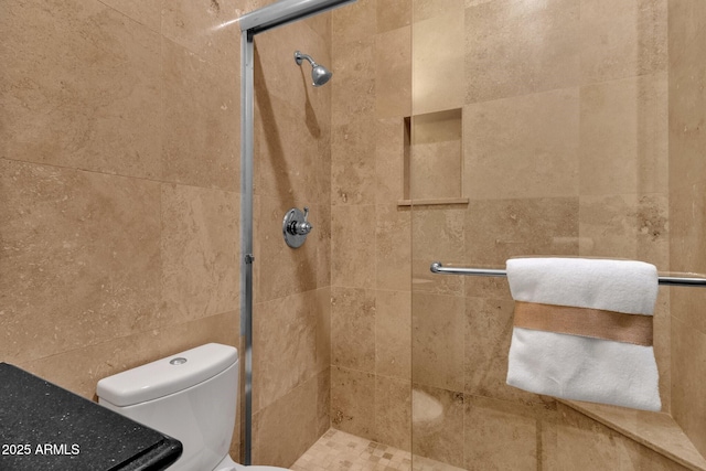 bathroom featuring a shower stall and toilet