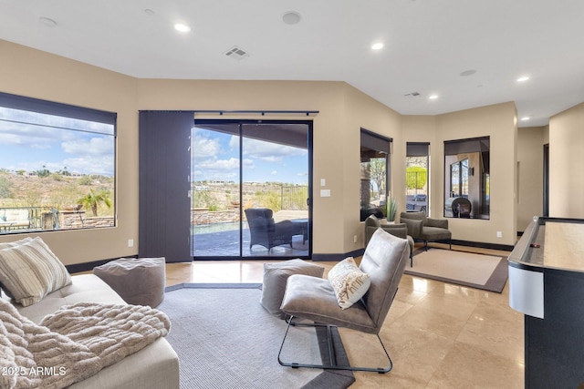 living area with recessed lighting, visible vents, and baseboards