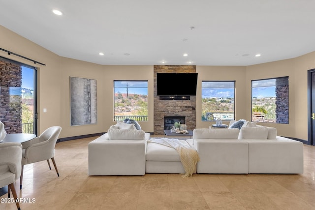 living area with a wealth of natural light, recessed lighting, and a large fireplace