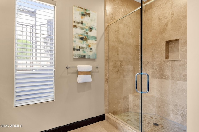 full bathroom featuring baseboards and a shower stall