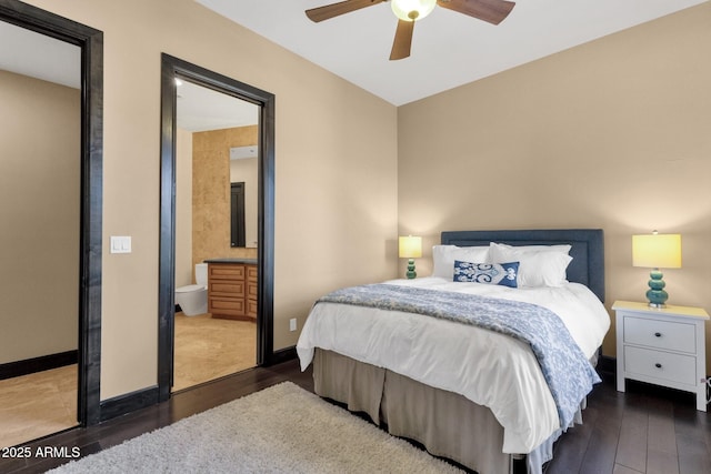 bedroom featuring a ceiling fan, ensuite bathroom, baseboards, and wood finished floors