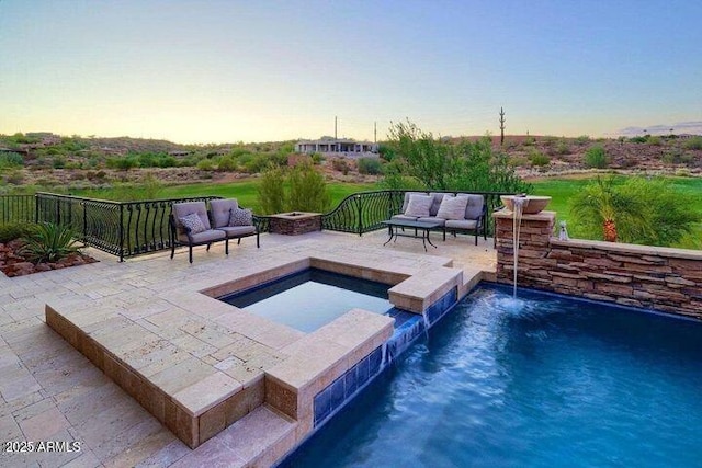 view of swimming pool featuring a pool with connected hot tub, an outdoor living space with a fire pit, and a patio