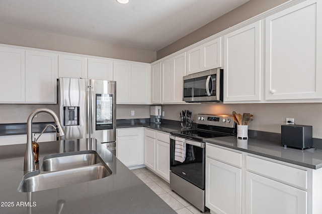 kitchen featuring sink, white cabinets, light tile patterned floors, and appliances with stainless steel finishes