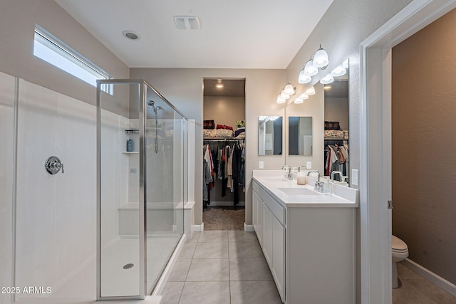 bathroom with toilet, a shower with door, vanity, and tile patterned floors