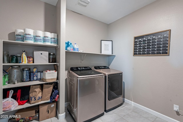 laundry area featuring washer and clothes dryer and light tile patterned flooring