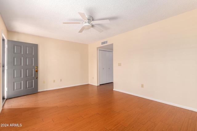 spare room with ceiling fan, hardwood / wood-style floors, and a textured ceiling