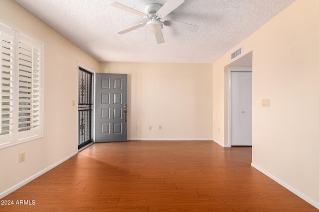 spare room with ceiling fan, a textured ceiling, and hardwood / wood-style flooring