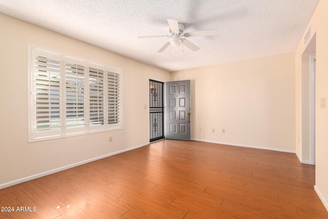 unfurnished room featuring ceiling fan, wood-type flooring, and a textured ceiling