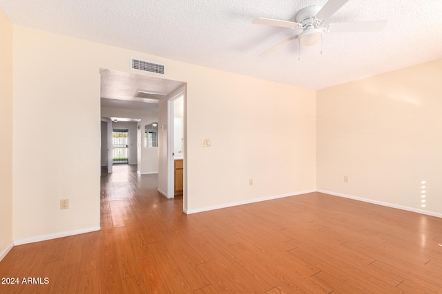 empty room featuring hardwood / wood-style floors, ceiling fan, and a textured ceiling