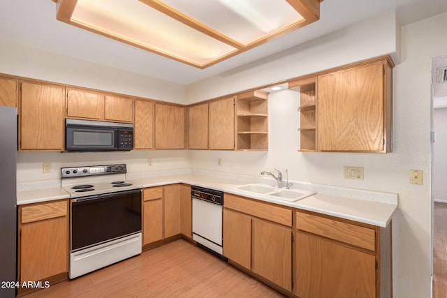 kitchen featuring light wood-type flooring, white appliances, and sink