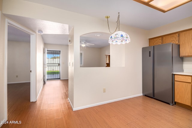 kitchen featuring stainless steel fridge, light hardwood / wood-style floors, hanging light fixtures, and ceiling fan