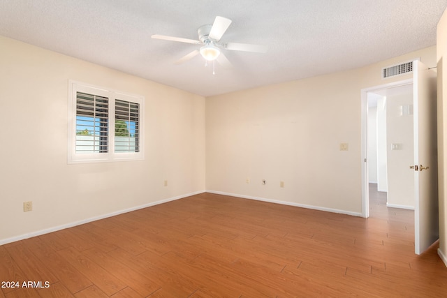 empty room featuring hardwood / wood-style flooring, ceiling fan, and a textured ceiling