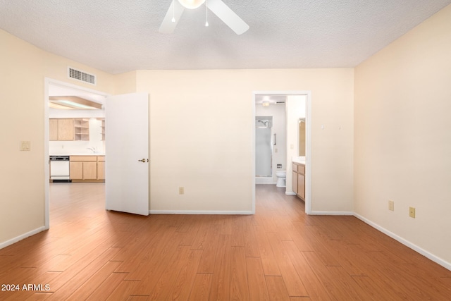 unfurnished bedroom with ensuite bath, ceiling fan, a textured ceiling, and light wood-type flooring