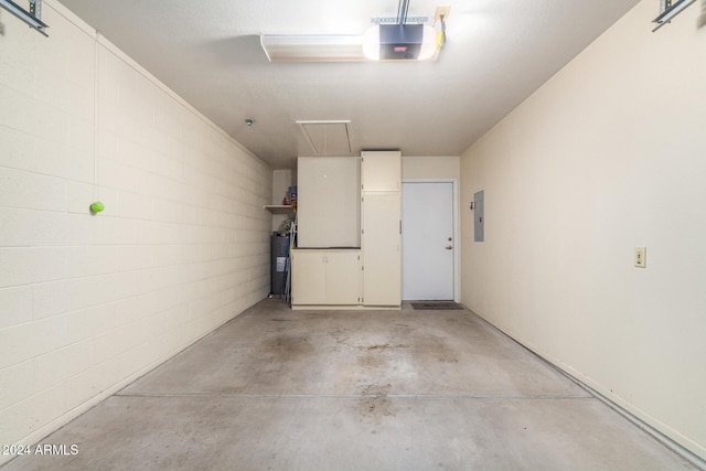 garage featuring electric panel, electric water heater, and a garage door opener