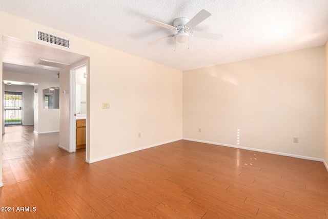 spare room featuring ceiling fan, a textured ceiling, and hardwood / wood-style flooring