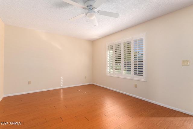 unfurnished room with hardwood / wood-style floors, ceiling fan, and a textured ceiling