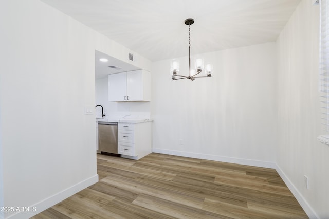 948 S Alma School Rd Unit 1, Mesa, AZ 85210 - unfurnished dining area featuring a chandelier and light wood finished floors