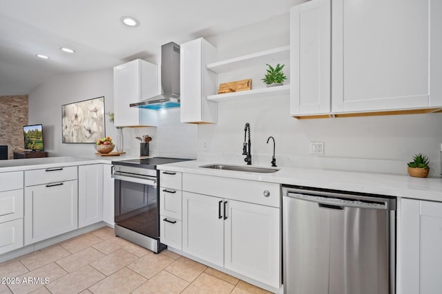 kitchen with stainless steel appliances, a sink, light countertops, wall chimney exhaust hood, and open shelves