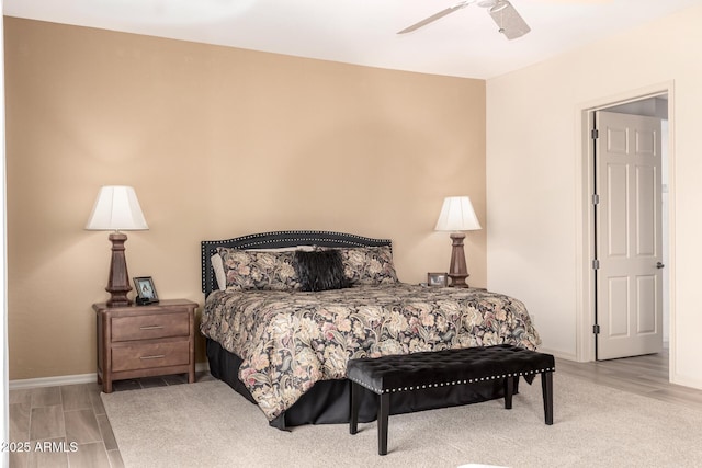 bedroom with light wood finished floors, ceiling fan, and baseboards