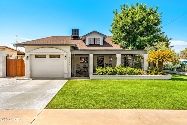 view of front of home featuring a garage, a front yard, and central AC