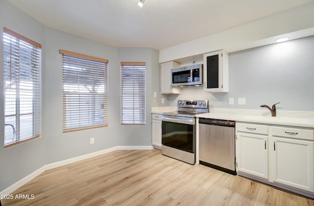 kitchen featuring a wealth of natural light, white cabinetry, sink, and stainless steel appliances