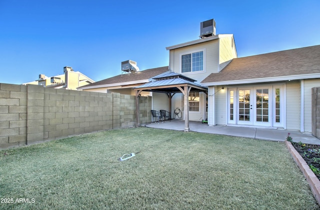 rear view of property featuring french doors, cooling unit, a gazebo, a patio area, and a yard