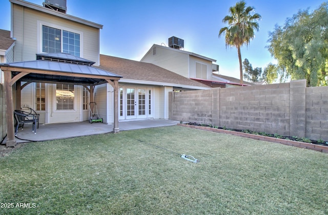 back of house with central AC unit, a yard, a patio, and french doors