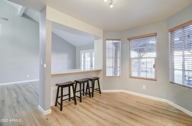 dining space featuring lofted ceiling and light wood-type flooring