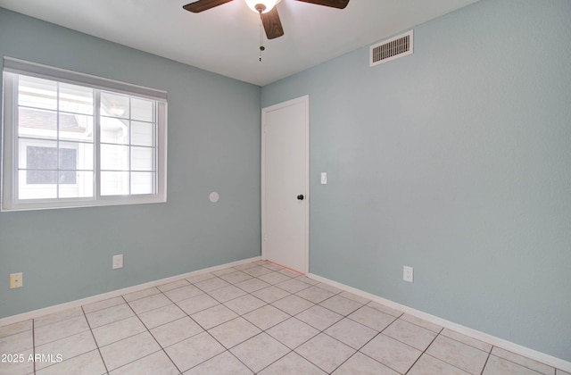 tiled spare room with ceiling fan