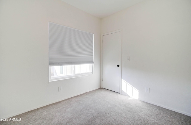 spare room featuring light carpet