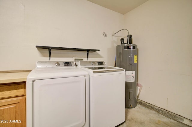 washroom featuring water heater, washer and clothes dryer, and cabinets