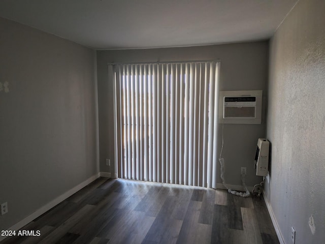 spare room featuring dark wood-type flooring and a wall mounted AC