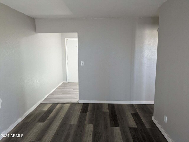 empty room with dark hardwood / wood-style flooring