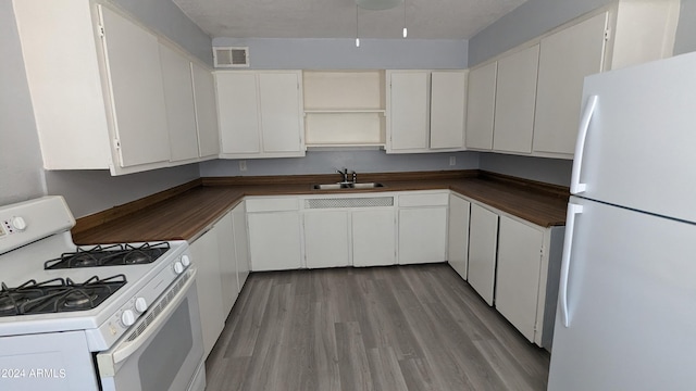 kitchen featuring light hardwood / wood-style floors, white cabinetry, sink, a textured ceiling, and white appliances