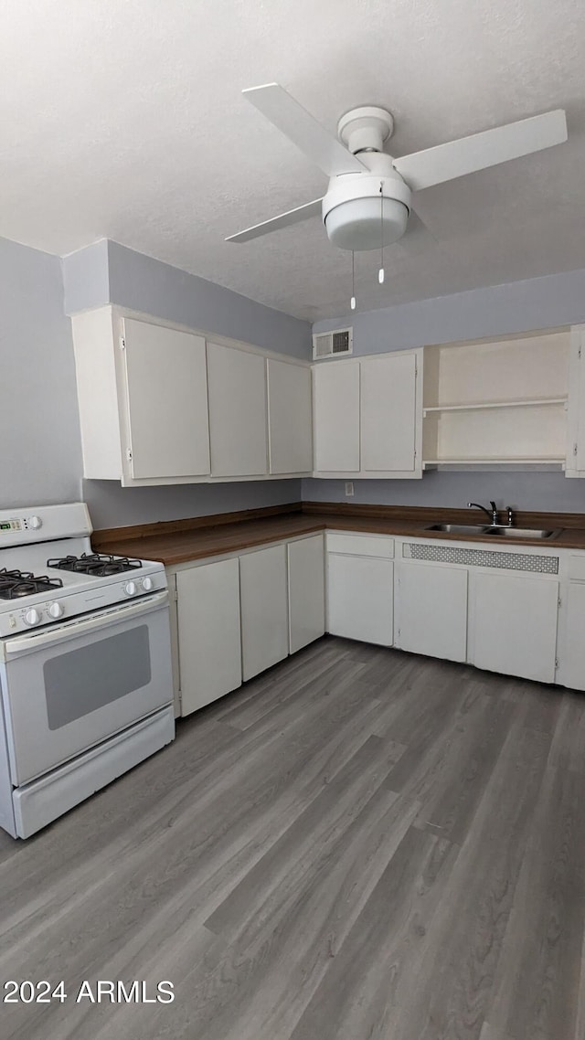 kitchen featuring white range with gas cooktop, light wood-type flooring, sink, white cabinets, and ceiling fan