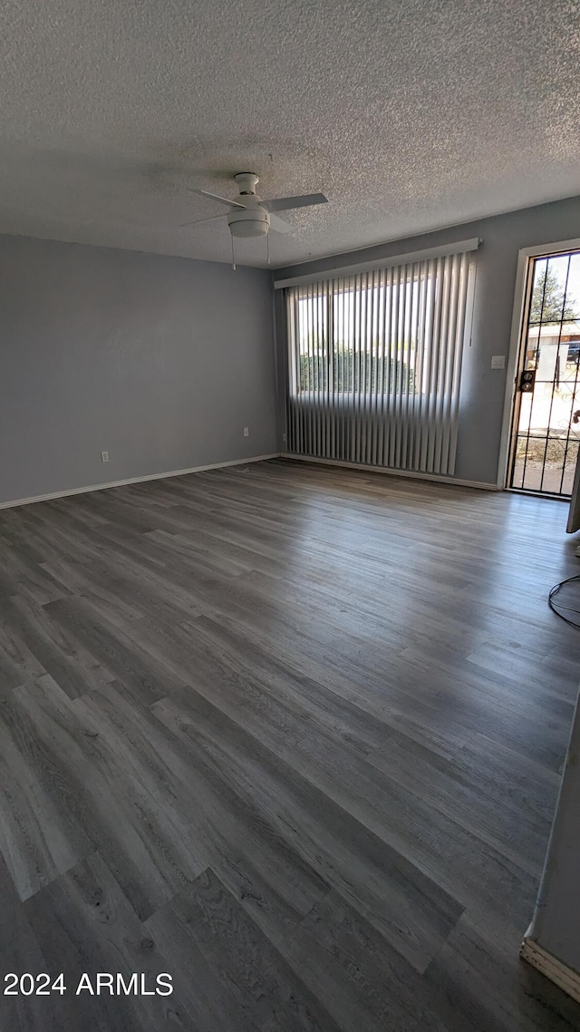 spare room featuring ceiling fan, a textured ceiling, and dark hardwood / wood-style floors