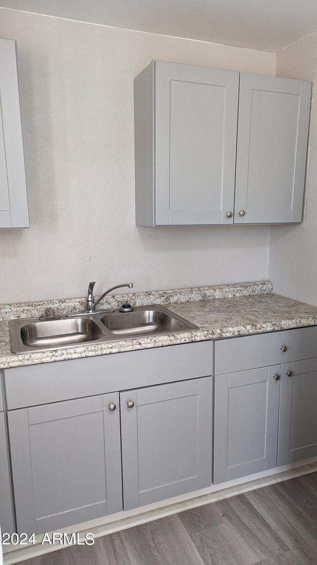 kitchen featuring hardwood / wood-style flooring, sink, and gray cabinets