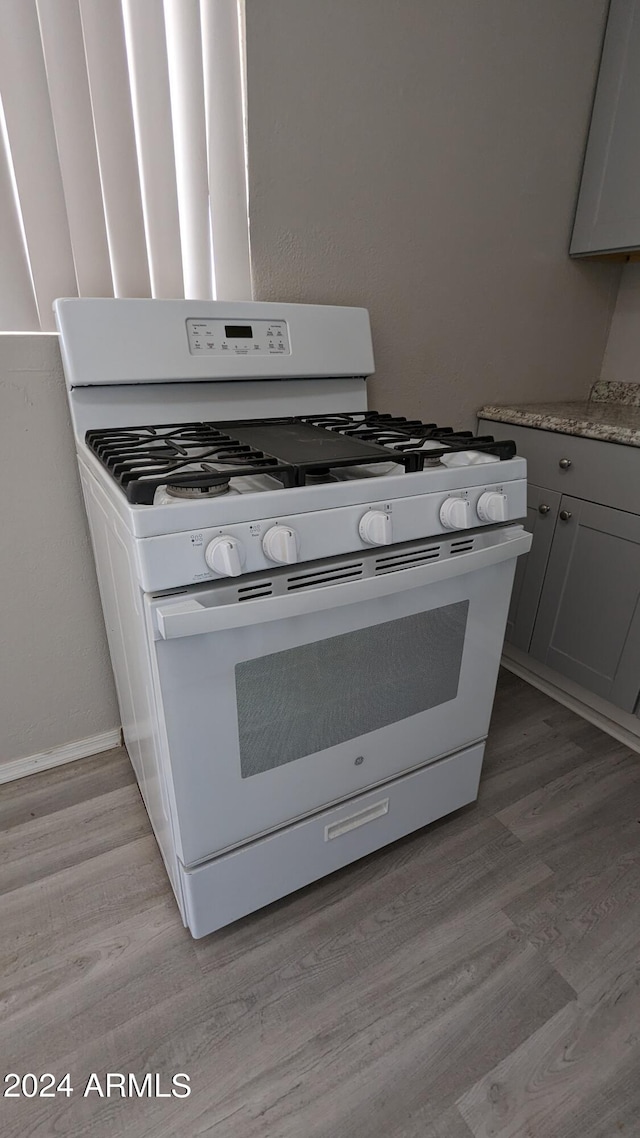 details with white range with gas cooktop and light hardwood / wood-style flooring